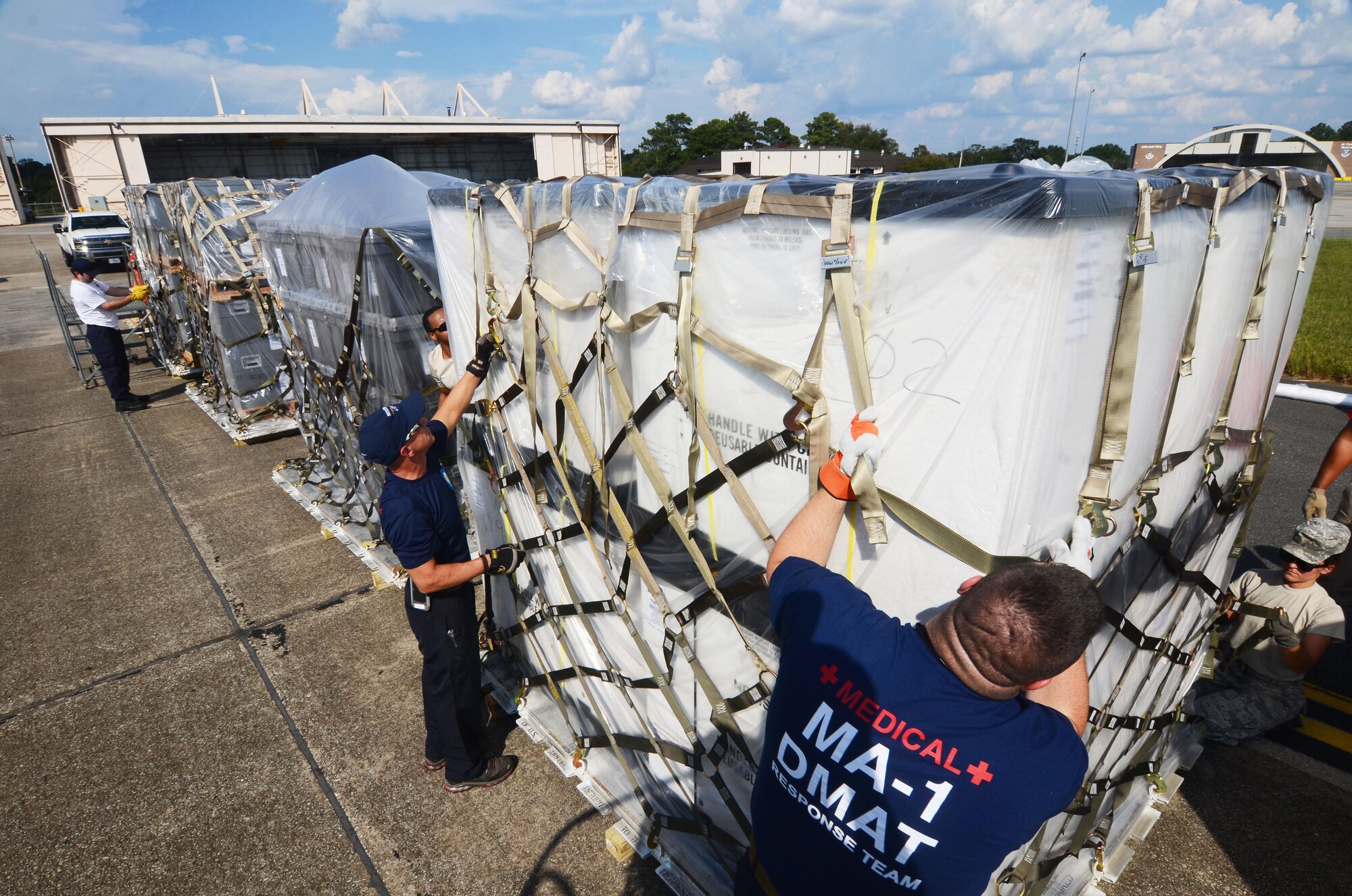 Disaster Medical Assistance Team members secure a cargo net around a pallet of medical supplies on the flightline at Dobbins Air Reserve Base, Ga. Sept. 21, 2017. The DMAT is a federalized workforce of doctors, nurses, paramedics, emergency management technicians, safety, and others who provide medical care during natural disaster relief efforts. (U.S. Air Force photo/Don Peek)