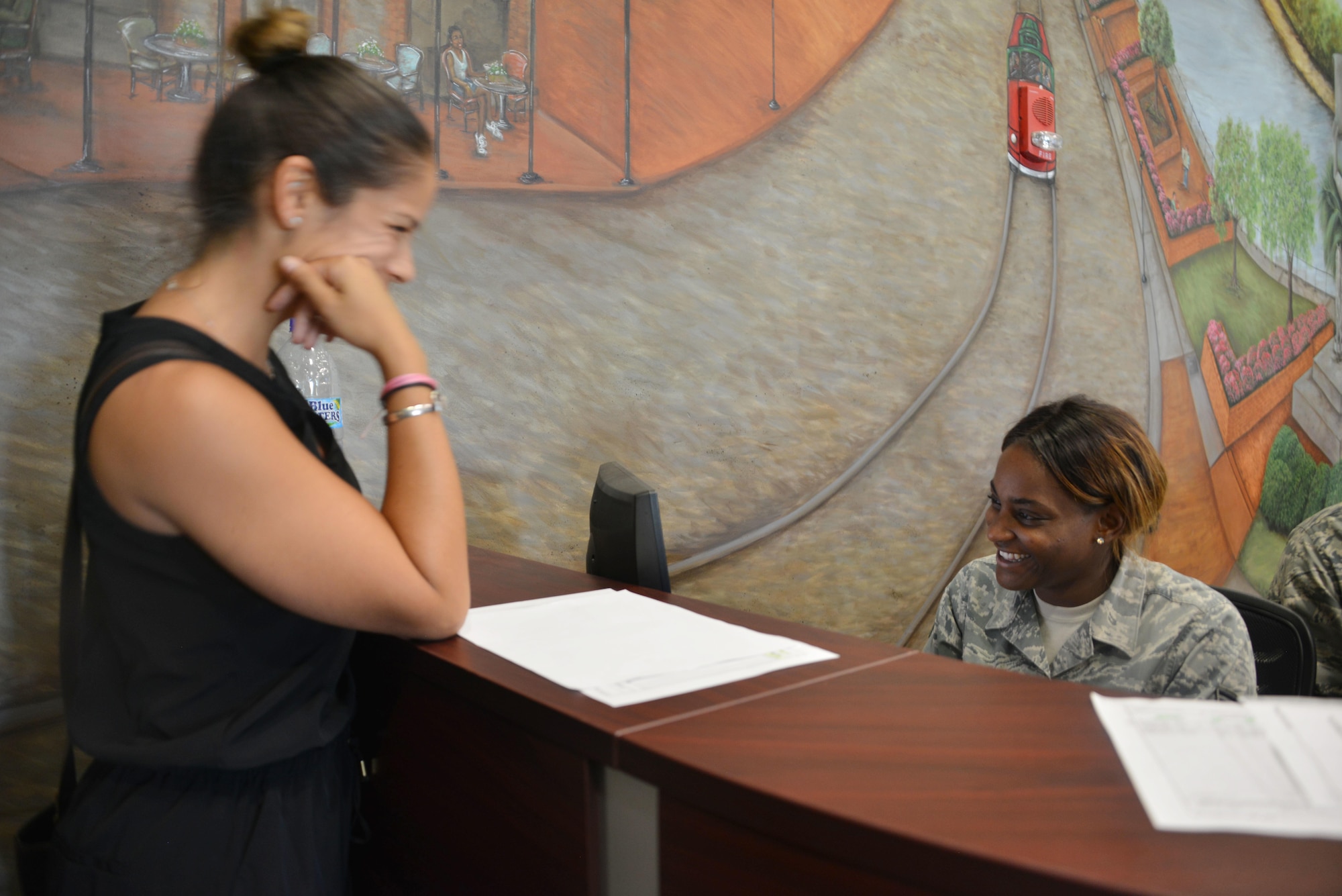 Staff Sgt. Tamika Taylor, of the 145th Force Support Squadron, checks in Carolina Boscan, a military spouse from St. Croix, Virgin Islands at the Savannah Air National Guard Base Sept. 24, 2017. Boscan arrived to the USO Reception Area after evacuating the Caribbean island hit by Hurricane Maria. Taylor and other personnel of the 145th and 165th Airlift Wings staff the 24-hour operation to receive service members and their family members circulating through hub-and-spoke missions at the wing. (U.S. Air National Guard photo/Staff Sgt. Chelsea Smith)