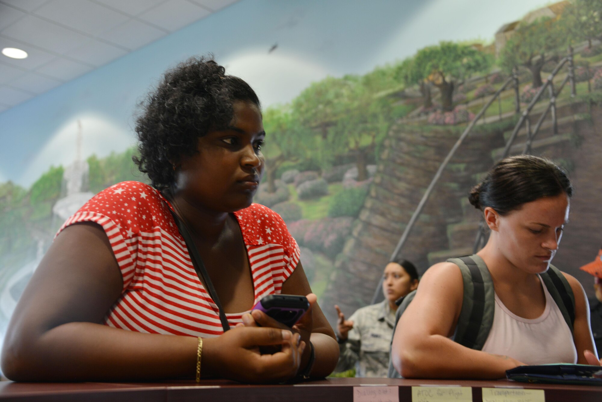Shantel Rogers, a military spouse who evacuated from St. Croix, Virgin Islands, awaits a lodging assignment at the Savannah Air National Guard Base, Sept. 24, 2017. The USO reception area provides food, toiletries and lodging assignments for service members supporting hurricane relief efforts and their families. (U.S. Air National Guard photo/Staff Sgt. Chelsea Smith)