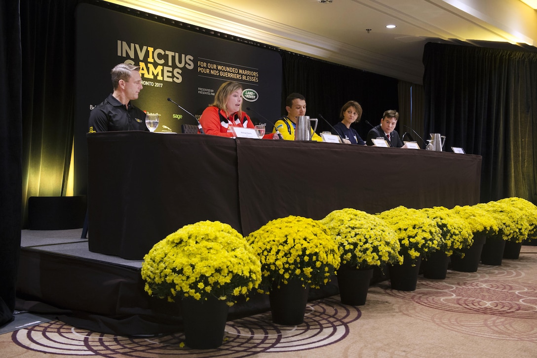 A panel of speakers hold a news conference.