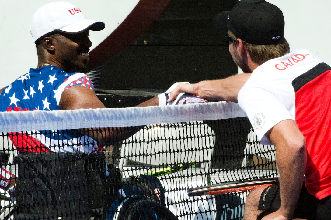 Two athletes shake hands after competing in wheelchair tennis.