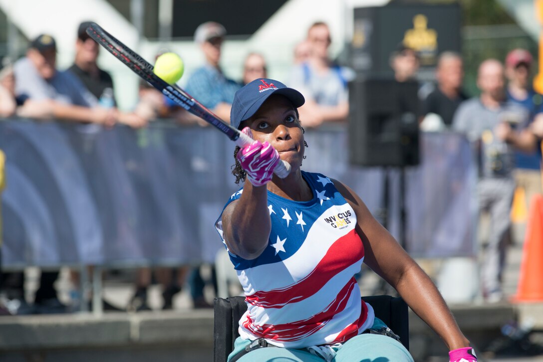 A Navy veteran hits a tennis ball during a wheelchair tennis match against the Canadian team.