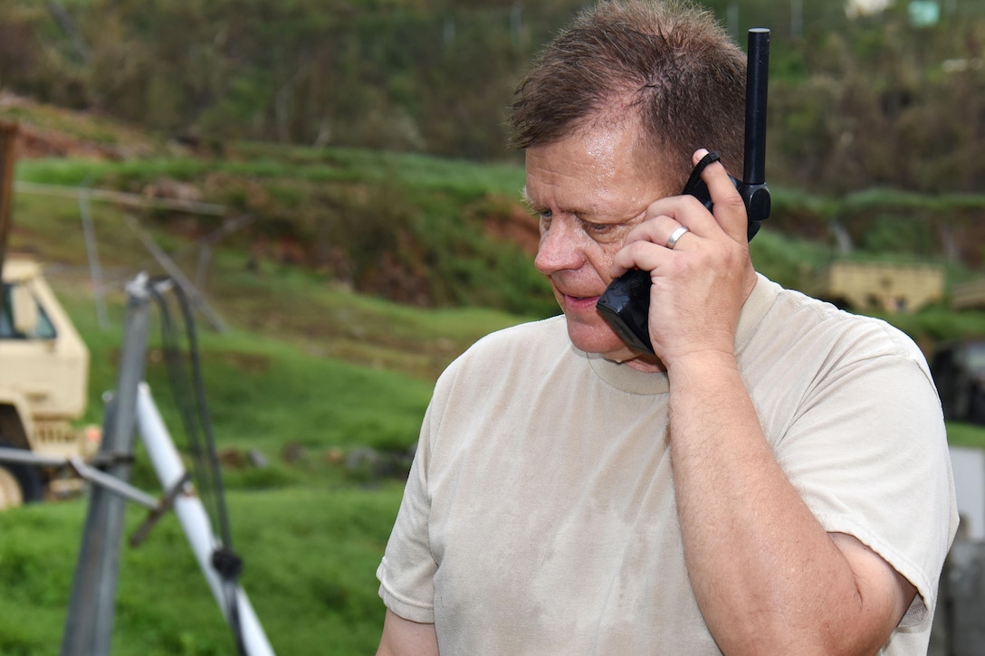 A service member uses an iridium satellite phone.