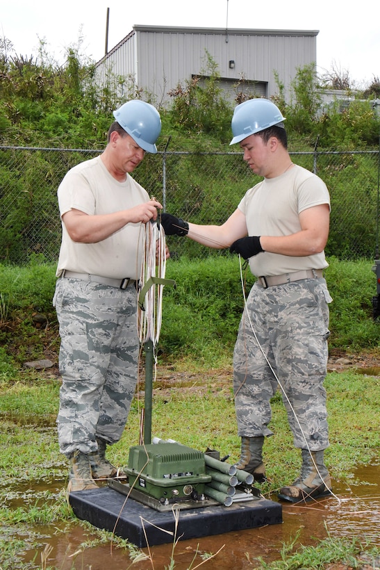 Service members erect a high frequency antenna.