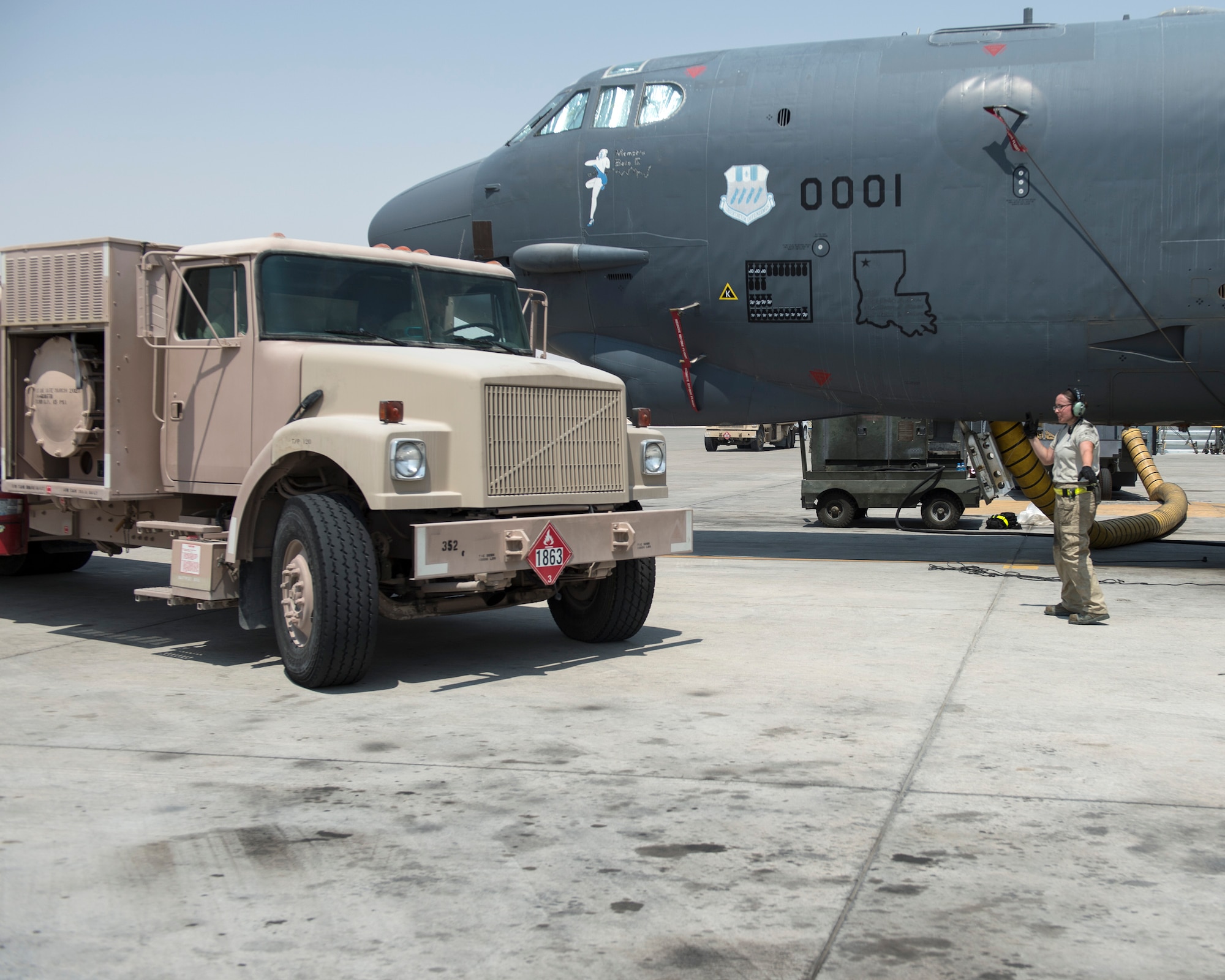 A U.S. Air Force crew chief with the 69th Expeditionary Aircraft Maintenance Unit marshals a fuel truck from the 379th Expeditionary Logistics Readiness Squadron, Fuels Management Flight, into position at Al Udeid Air Base, Qatar, Sept. 14, 2017.