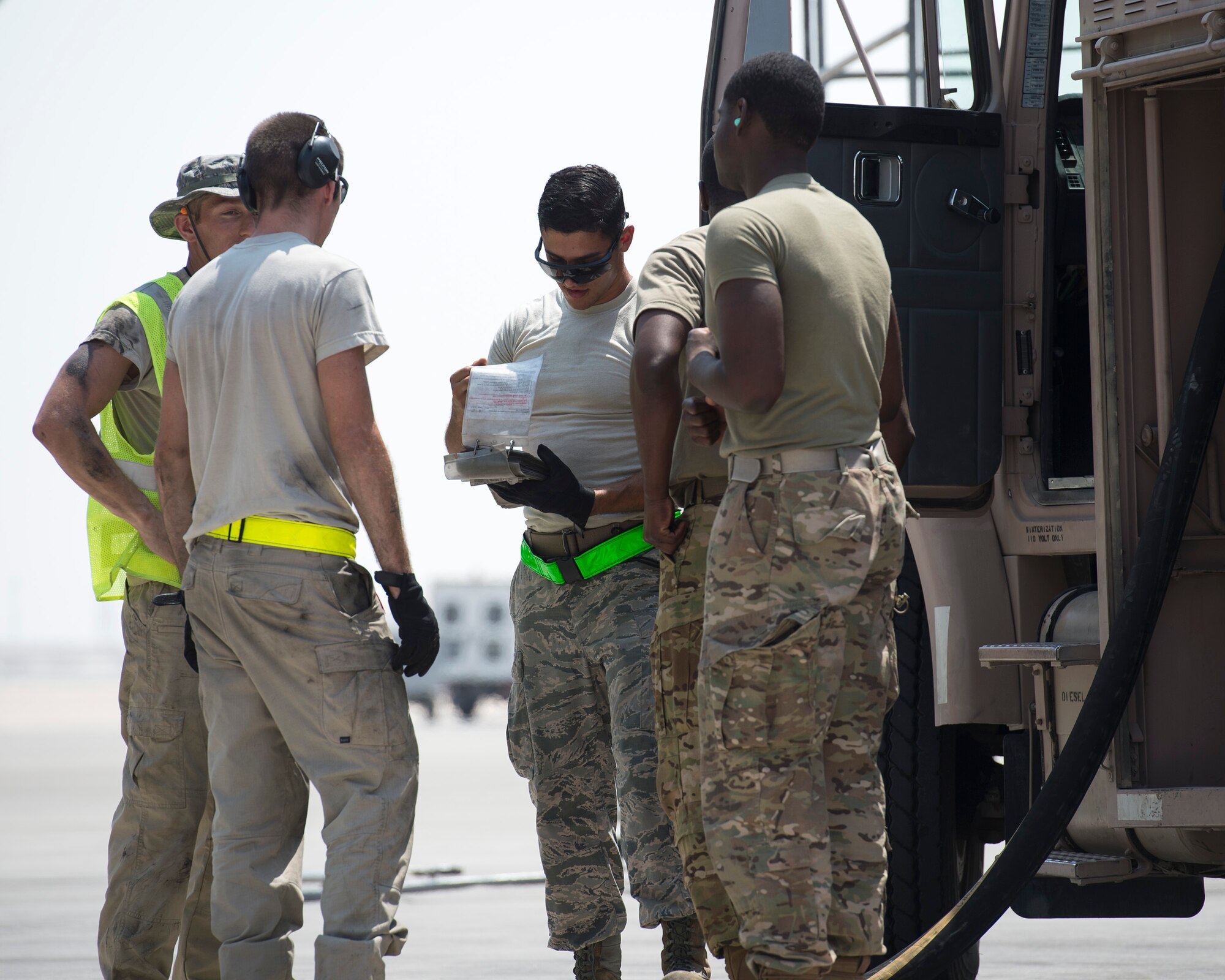 U.S. Air Force Senior Airman Yahya Elgazar, center, fuels distribution technician with the 379th Expeditionary Logistics Readiness Squadron, Fuels Management Flight, reviews the checklist at Al Udeid Air Base, Qatar, Sept. 14, 2017.