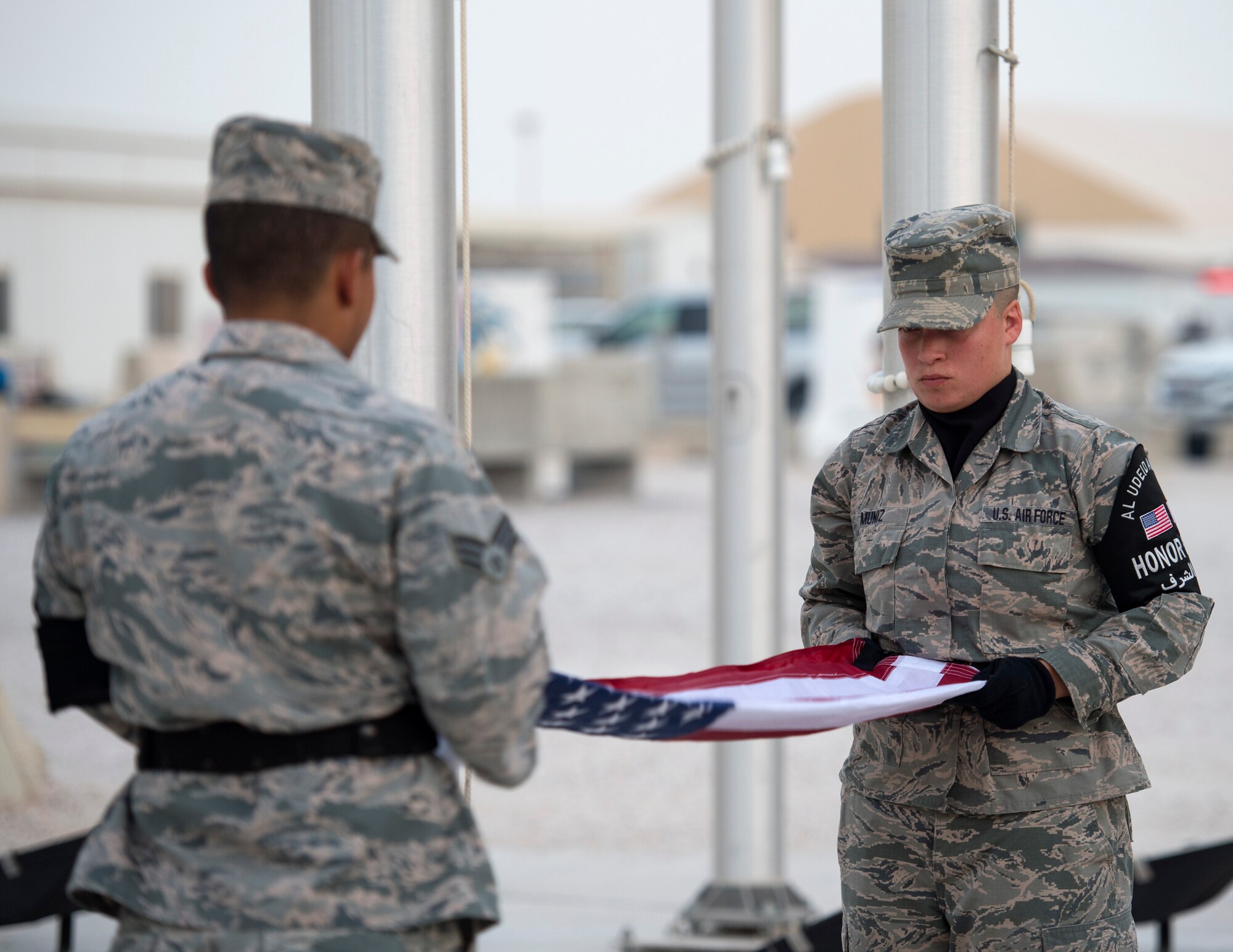 U.S. Air Force Airmen with the Al Udeid Air Base Honor Guard prepare to fold a U.S. flag during a 9/11 retreat ceremony at Al Udeid Air Base, Qatar, Sept. 1, 2017.
