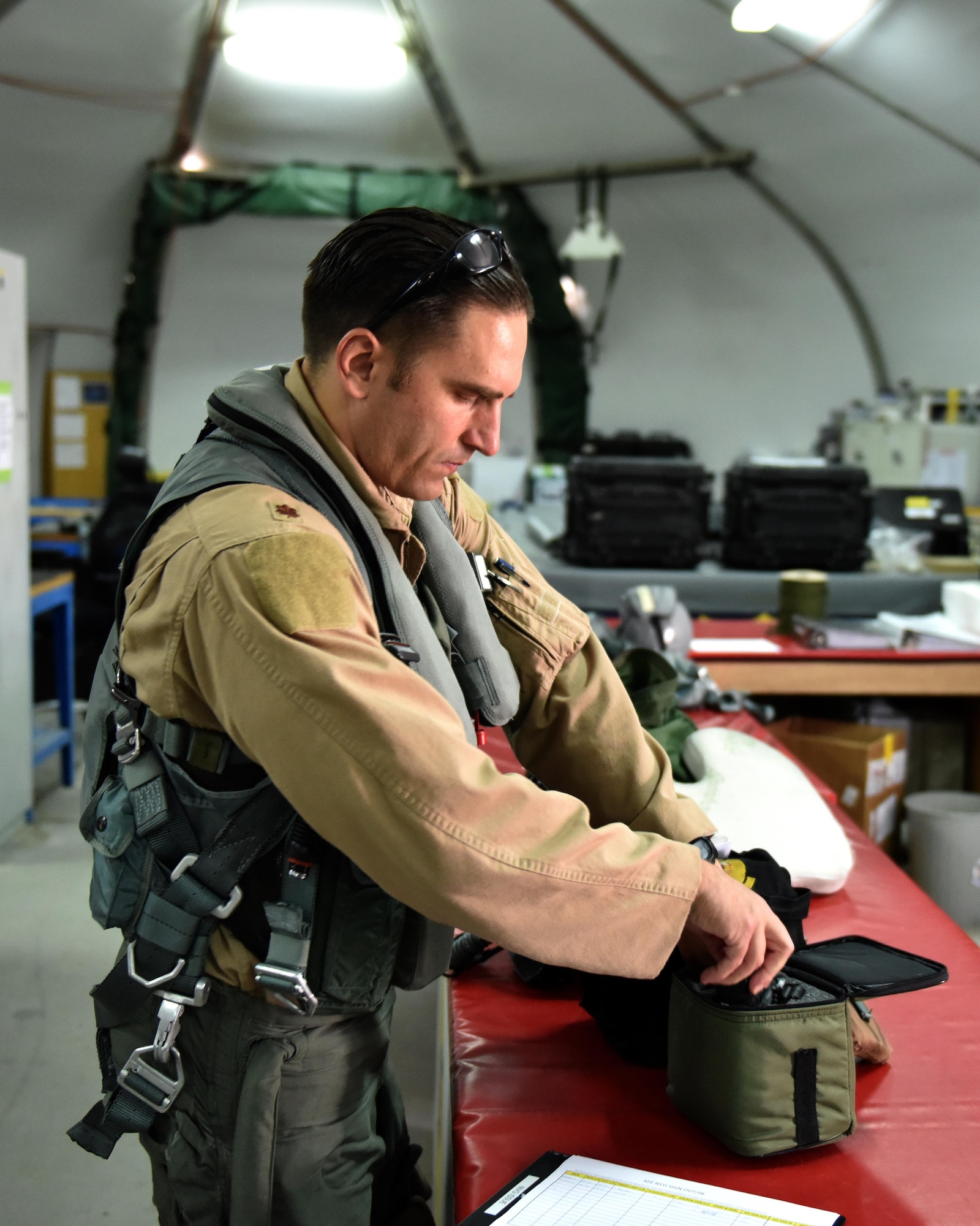 Maj. “Bullet,” F-22 Raptor pilot with the 27th Expeditionary Fighter Squadron, prepares his equipment prior to flight in support of Combined Joint Task Force-Operation Inherent Resolve at Al Dhafra Air Base, United Arab Emirates, Sept. 22, 2017.