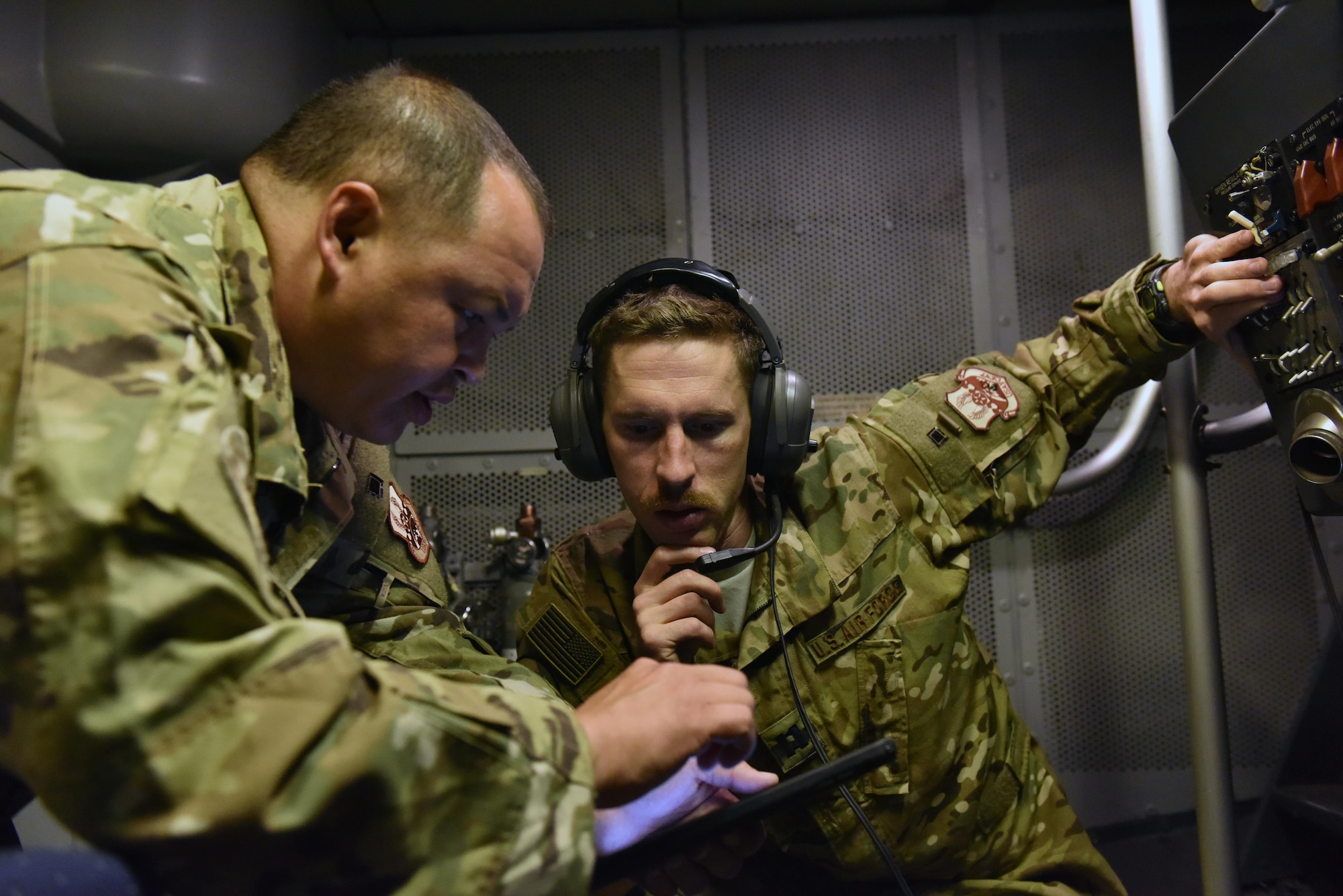 Capt. Joe, right, assists boom operator Tech. Sgt. Fritz in trouble shooting an issue in a KC-10 Extender boom pod in the air over Syria, Sept. 13, 2017.