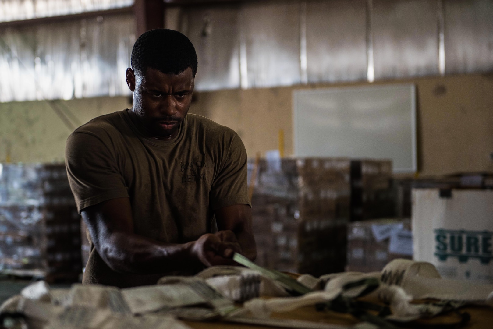 U.S. Army Sgt. Timothy Williams, a parachute rigger assigned to the 824th Quartermaster Company, pulls a strap to tighten an airdrop bundle at an undisclosed location in Southwest Asia, Sept. 6, 2017. Airdrop bundles are rigged within specific guidelines to ensure the cargo properly exits the aircraft, the parachute properly deploys and the bundle lands intact on its target. (U.S. Air Force photo by Tech. Sgt. Jonathan Hehnly)