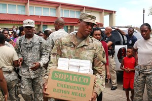 A soldier carries a box of supplies.