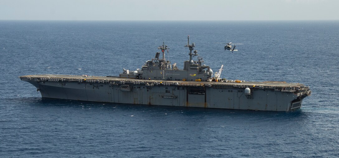 An MH-60S Sea Hawk helicopter prepares to land on the flight deck of the amphibious assault ship USS Wasp (LHD 1) for refueling during humanitarian relief efforts on Dominica