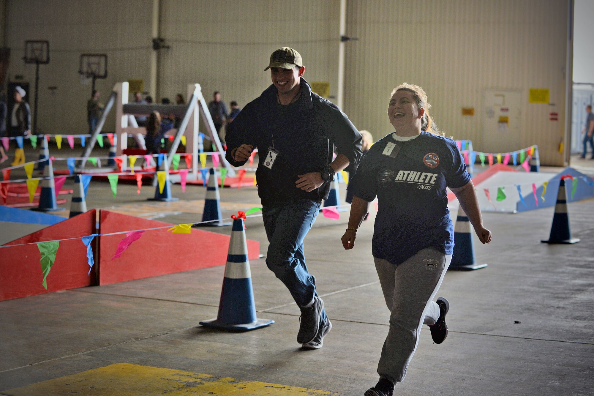 An athlete and her escort race against one another during 100-yard race at the Joan Mann Special Sports Day, Sept. 23, 2017, on RAF Mildenhall, England. The event included an obstacle course, basketball shoot-out, ball toss and other competitions for the athletes. (U.S. Air Force photo by Senior Airman Christine Groening)