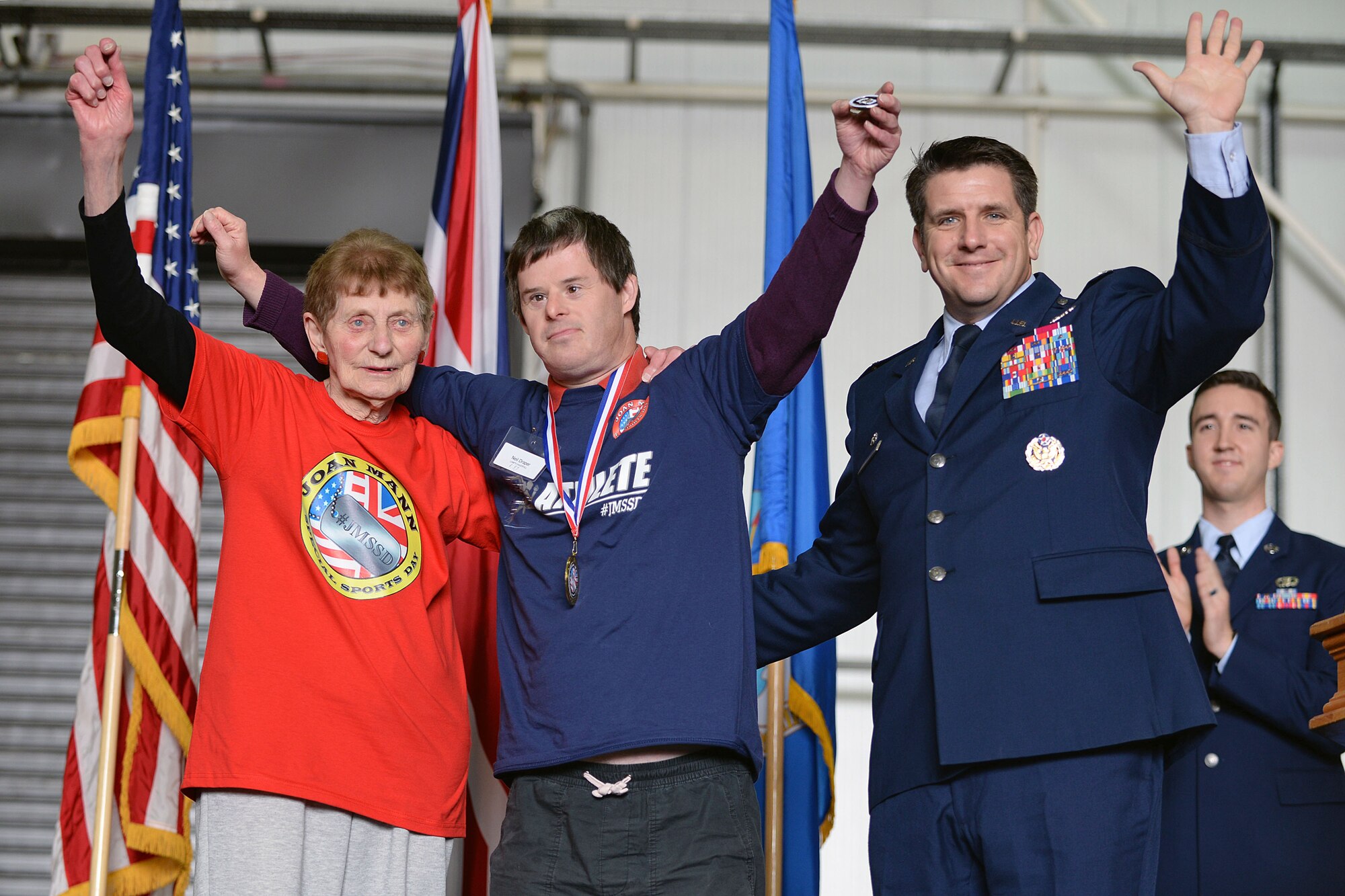 U.S. Air Force Col. Christopher Amrhein, 100th Air Refueling Wing Commander, right, poses for a photograph with special needs athlete Neil Draper, and volunteer and Iris Weimer, during the closing ceremony of the 36th annual Joan Mann Special Sports Day, Sept. 23, 2017, on RAF Mildenhall, England. Draper was recognized by Amrhein for being the only athlete to have participated in all 36 Joan Mann Special Sports Days events. (U.S. Air Force photo by Senior Airman Christine Groening)