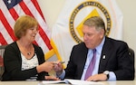 James P. Hoffa (right), general president of the International Brotherhood of Teamsters, and Karen M. Perkins (left), director of human resources (G1) for the U.S. Army Installation Management Command, sign a memorandum of
understanding to encourage garrisons to partner with Teamsters locals and trucking companies to set up truck driver training programs for transitioning Soldiers. The ceremony took place Sept. 18 at IMCOM headquarters at Joint Base San Antonio-Fort Sam Houston.
