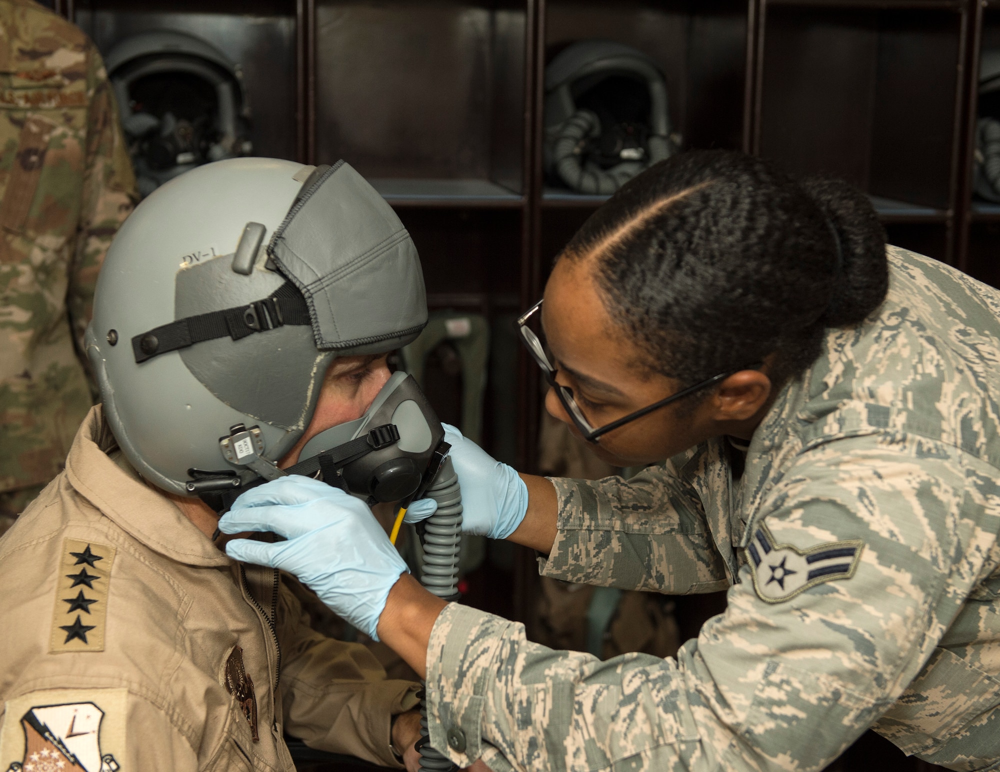 U.S. Air Force Airmen 1st Class Zilcia Williams, a 379th Expeditionary Operational Support Squadron aircrew flight equipment technician with the, helps U.S. Army Gen. Joseph Votel, left, U.S. Central Command commander, with his helmet at Al Udeid Air Base, Qatar, Sept. 8, 2017.