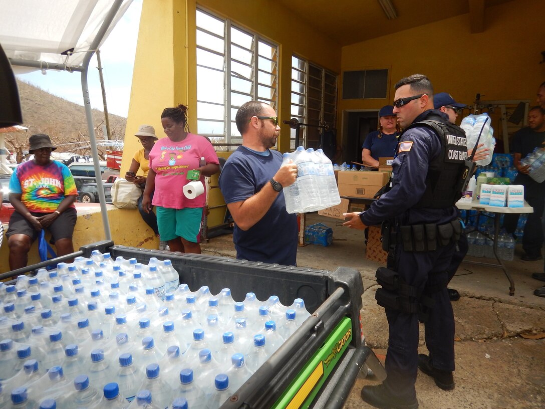 The crew of the Coast Guard Cutter Joseph Napier offloads 450 liters of water for the people of Coral Bay.