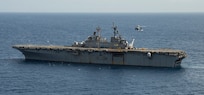 An MH-60S Sea Hawk helicopter prepares to land on the flight deck of the amphibious assault ship USS Wasp (LHD 1) for refueling during humanitarian relief efforts on Dominica