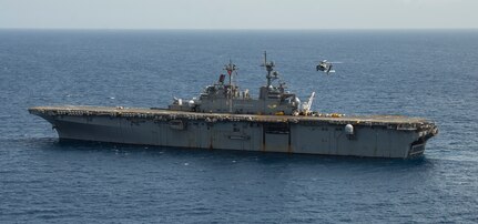 An MH-60S Sea Hawk helicopter prepares to land on the flight deck of the amphibious assault ship USS Wasp (LHD 1) for refueling during humanitarian relief efforts on Dominica