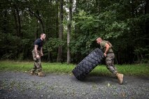 FFIT Sgt. Cody Anderson monitors form and motivates a Marine executed a tire flip during a Physical Training session as part of Force Fitness Instructor Course 4-17.