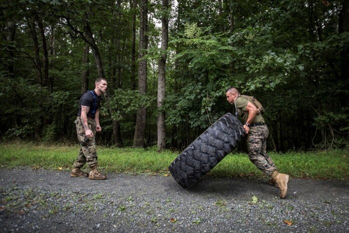 FFIT Sgt. Cody Anderson monitors form and motivates a Marine executed a tire flip during a Physical Training session as part of Force Fitness Instructor Course 4-17.