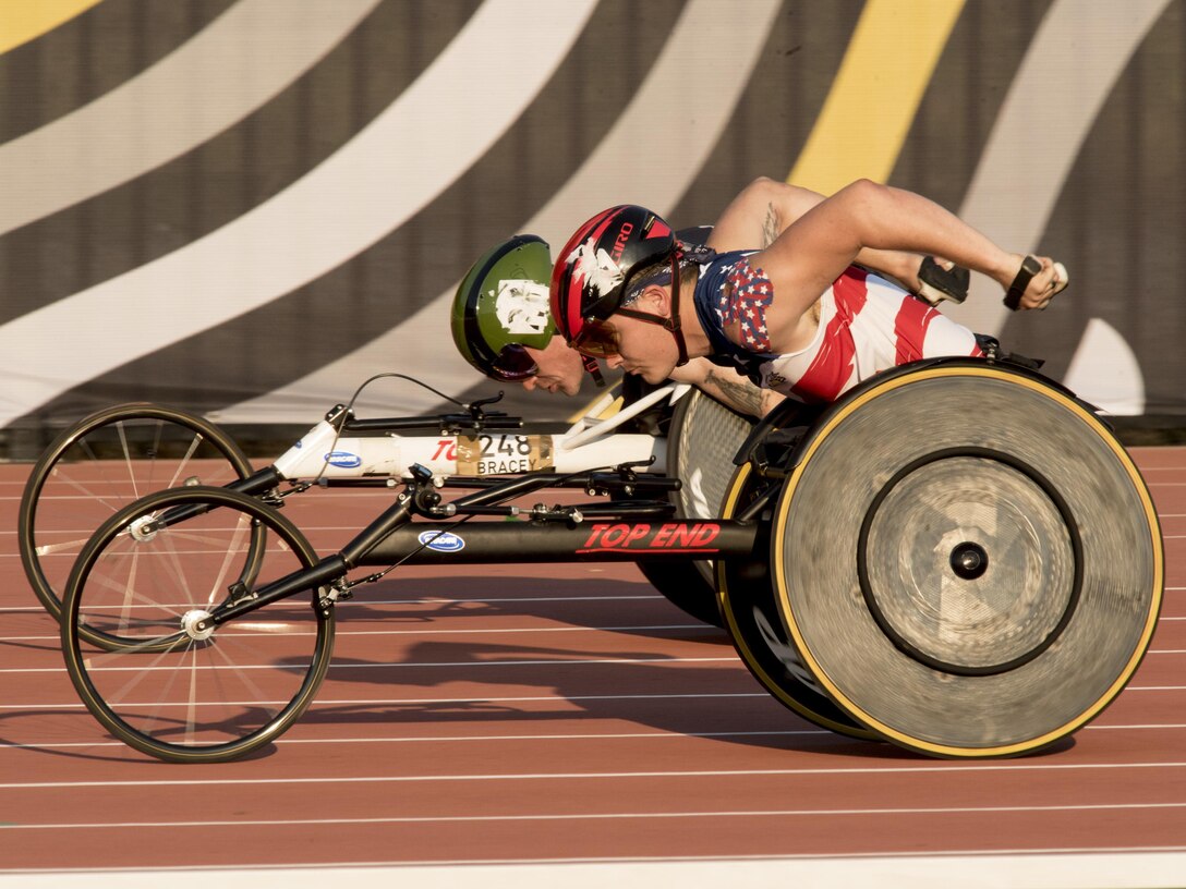 A Team U.S. member passes a Team Great Britain member in a wheelchair race.