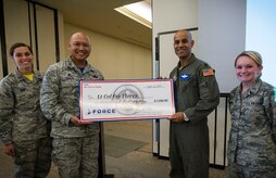 Col. Jimmy Canlas, 437th Maintenance Group commander, left, presents a check to Lt. Col. Francisco Flores, 437th Operations Support Squadron director of operations, right, during the U.S. Air Force’s 70th Anniversary celebration at the Charleston Club, Sept. 22, 2017.