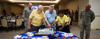 U.S. Air Force retirees Tech. Sgt. Leonard Flesher, left, and Tech. Sgt. Samuel Fried, perform the ceremonial cake cutting with Airman 1st Class Lorelie Budionganon, 628th Force Support Squadron personnel specialist, to celebrate the Air Force’s 70th Anniversary at the Charleston Club,  Sept. 22, 2017.