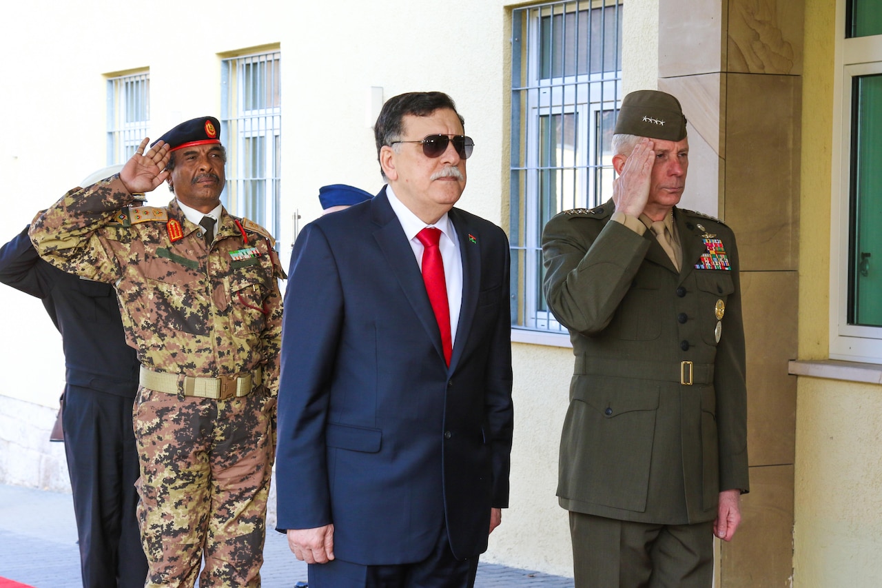 Libyan prime minister and U.S. Africom commander render honors at ceremony before a meeting.