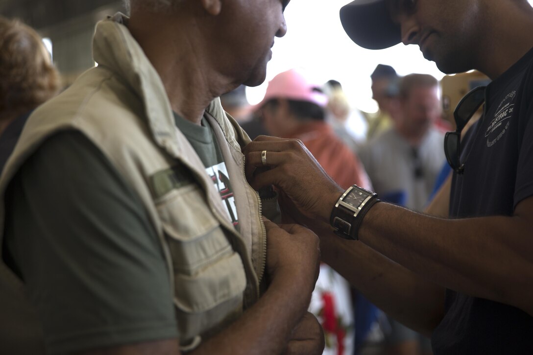 A son gives a lapel pin to his father to recognize his service during the Vietnam War, during a pinning ceremony at the 2017 Marine Corps Air Station Miramar Air Show on MCAS Miramar, Calif., Sept. 22. “The 2017 MCAS Miramar Air Show gives the public and current service members an opportunity to say thank you to the veterans of the Vietnam War,” said Col. Jason Woodworth, commanding officer of MCAS Miramar. “Our goal is to remind the veterans that the country cares about them and truly values the sacrifice they made for the American people, regardless of how they were treated when they initially returned from Vietnam.” (U.S. Marine Corps photo by Sgt. Lillian Stephens/Released)