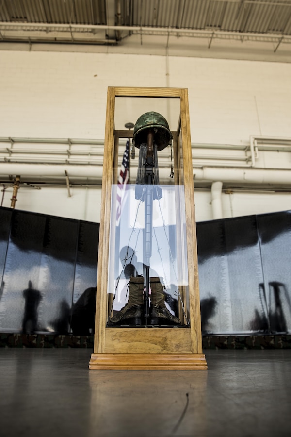 Veterans, family members and other guests stand quietly during the invocation of a pinning ceremony at the Mobile Vietnam Memorial Wall, also known as the AV Wall, during the 2017 Marine Corps Air Station Miramar Air Show at MCAS Miramar, Calif., Sept. 23. AV Wall volunteers, family members and active duty service members gave lapel pins to Vietnam veterans to commemorate their service and express gratitude. (U.S. Marine Corps photo by Sgt. Lillian Stephens/Released)