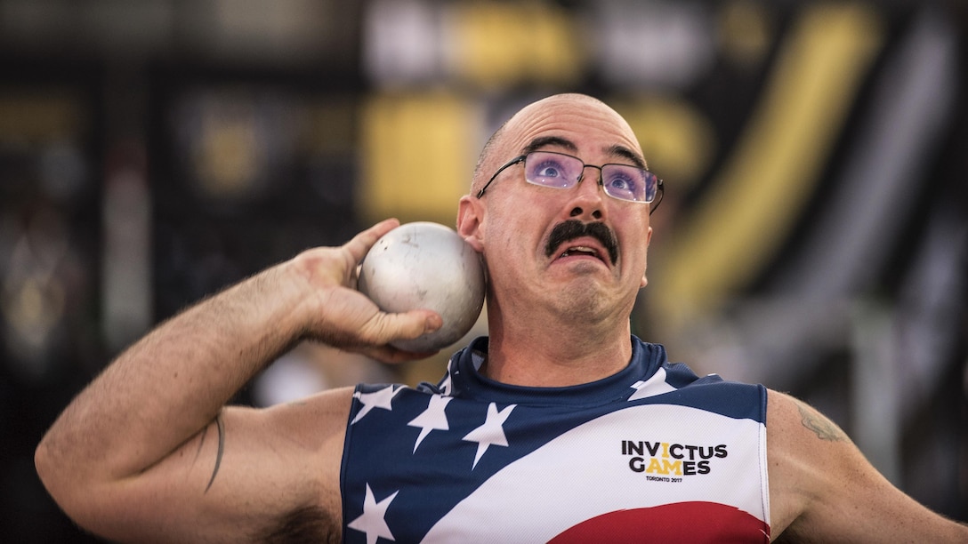 An airman makes a face as he prepares to throw a shot put.