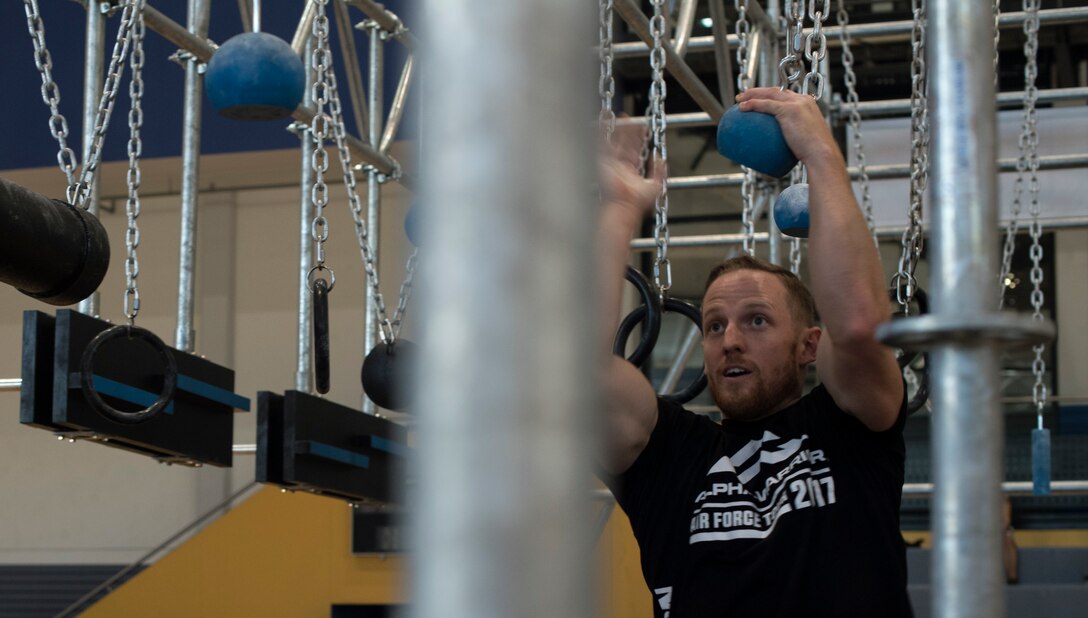 Kevin Klein, Alpha Warrior pro, swings while demonstrating how to successfully cross a portion of the Alpha Warrior’s Battle Rig obstacle course during the Alpha Warrior Tour on Ramstein Air Base, Germany, Sept. 22, 2017. Klein, along with two other Alpha Warrior pros, traveled with the tour to teach Airmen the best techniques for completing the course. (U.S. Air Force photo by Senior Airman Tryphena Mayhugh)