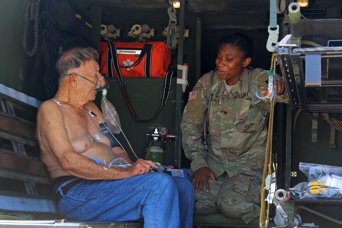 A soldier speaks to a seated patient.