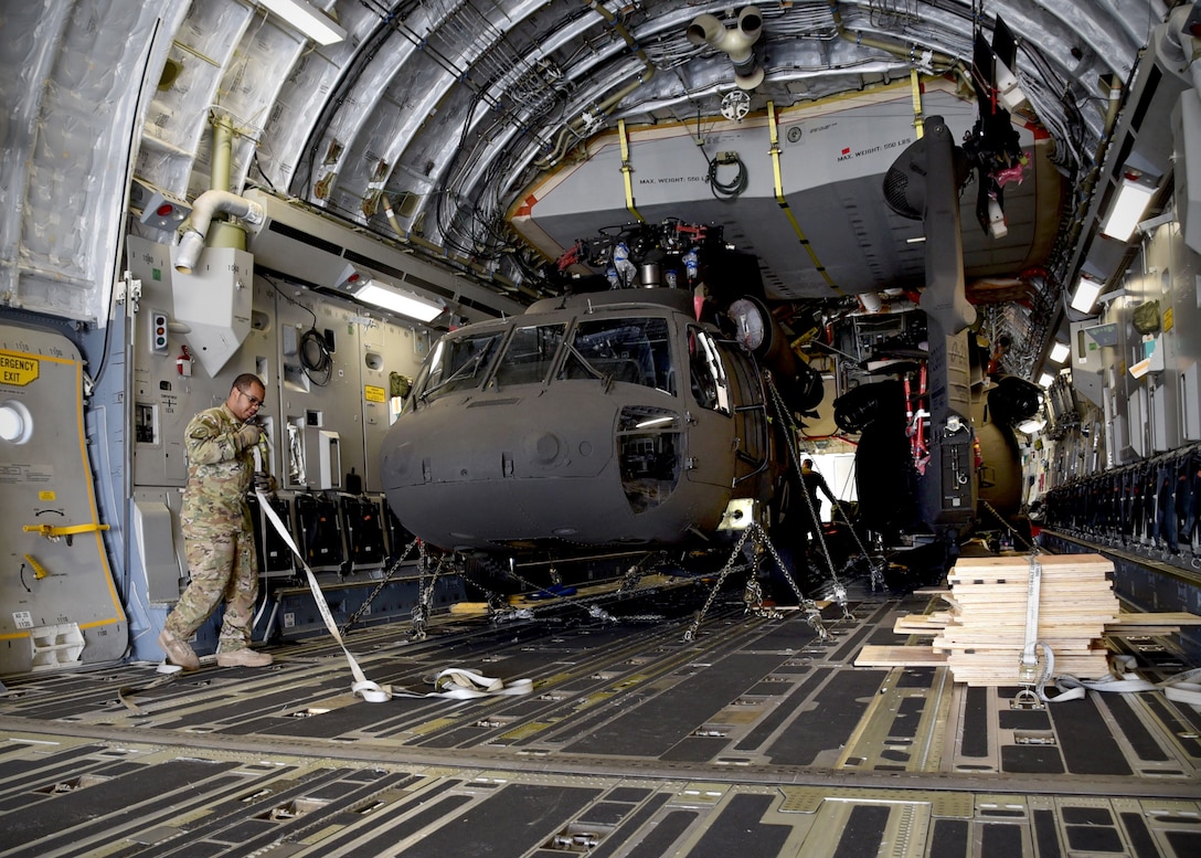 A U.S. Air Force C-17 loadmaster assigned to Charleston Air Force Base, S.C., prepares two Afghan Air Force UH-60 helicopters for unloading Sept. 18, 2017, at Kandahar Air Field, Afghanistan. These are the first UH-60s to be delivered to Afghanistan for the modernization of the AAF and development of a professional, capable and sustainable Afghan Air Force.