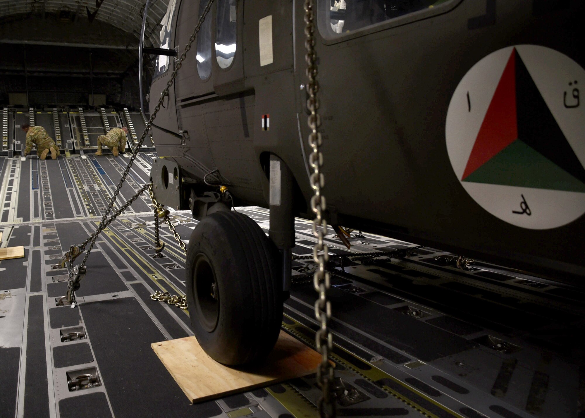 A U.S. Air Force C-17 loadmaster assigned to Charleston Air Force Base, S.C., prepares two Afghan Air Force UH-60 helicopters for unloading Sept. 18, 2017, at Kandahar Air Field, Afghanistan. These are the first UH-60s to be delivered to Afghanistan for the recapitalization of the AAF and development of a professional, capable and sustainable Afghan Air Force. (U.S. Air Force photo by Tech. Sgt. Veronica Pierce)