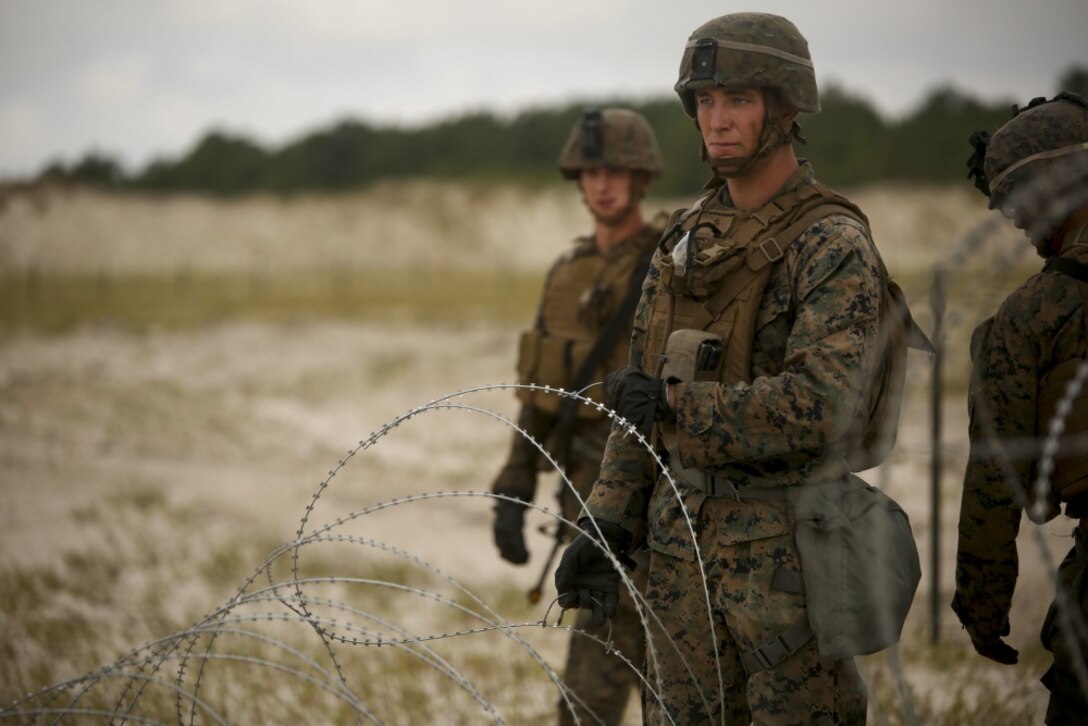 A Marine unravels barbed wire in order to set up a secure boundary during a field training exercise at Camp Lejeune, N.C., Sept. 17-21, 2017. The field exercise prepares Marines for future deployments though events including engineer reconnaissance, helicopter operations, improvised explosive device lanes with route clearing courses, survivability tasks, breeching, and urban operations. The Marines are with 2nd Combat Engineer Battalion. (U.S. Marine Corps photo by Lance Cpl. Gloria Lepko)