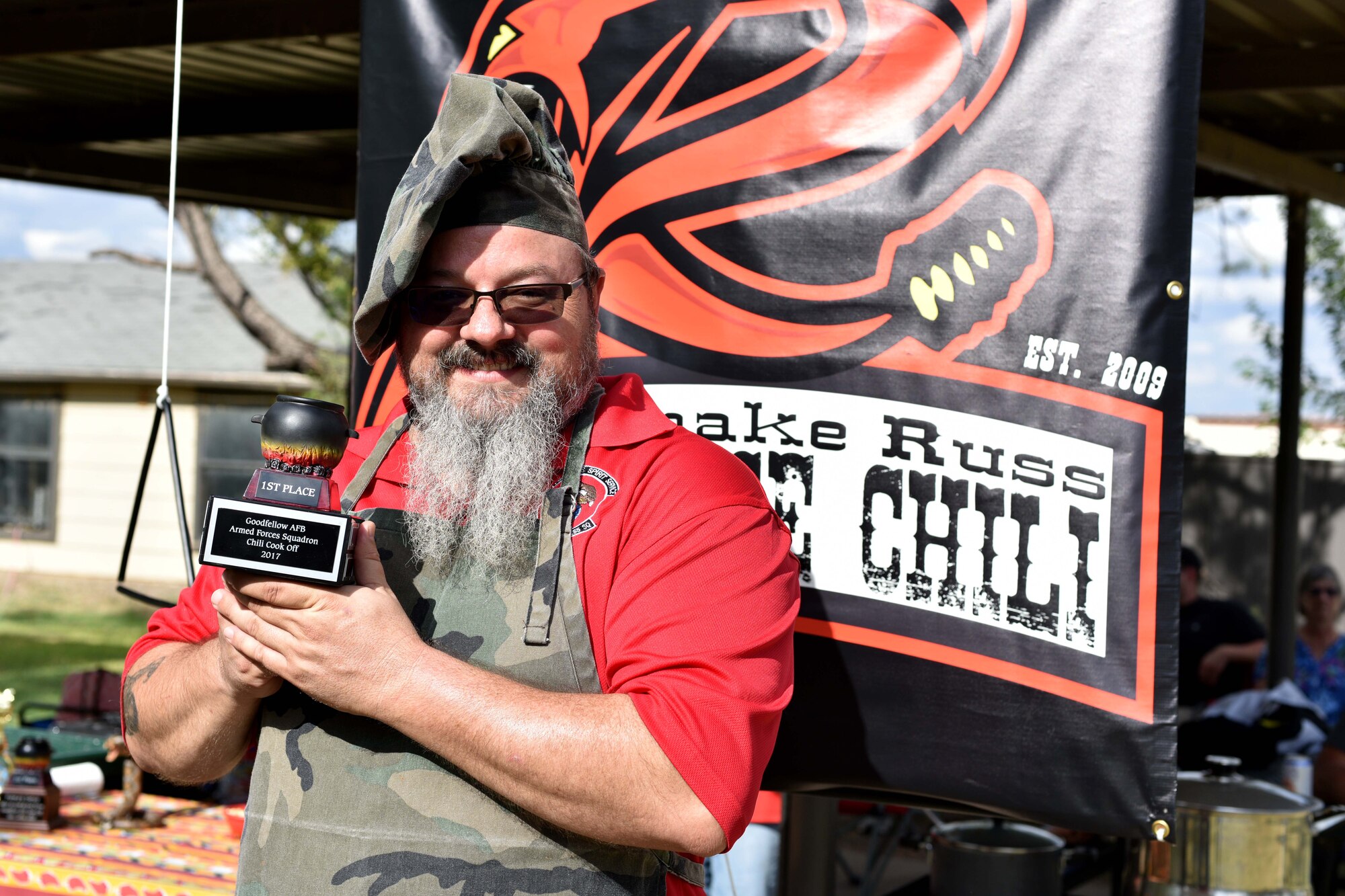 Russell Dunlap, 312th Training Squadron supply technician, holds the Goodfellow Air Force Base Armed Forces Squadron Chili Cook-Off trophy during the Ruckus at the Rec Camp at the Goodfellow Air Force Base Recreation Camp, San Angelo, Texas, Sept. 23, 2017. The Ruckus is a combination of the 44th Annual Armed Forces Chili-Off, the 19th Annual Car and Bike show and a BBQ cook-off. (U.S. Air Force photo by Airman 1st Class Randall Moose/Released)