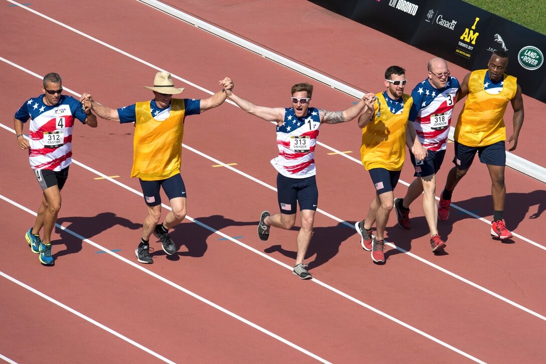 Team U.S. members, visually impaired runners join hands to finish their 1500 meter race.