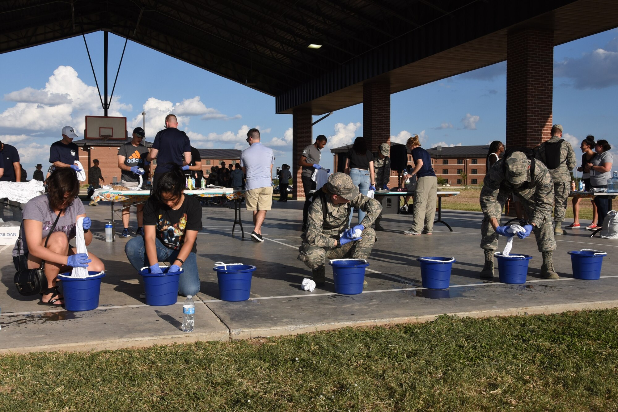 Students prepare to tie-dye shirts by soaking them in water before moving on to another table to pick the patterns and colors they wish to use during the evet to dye for at the marching pad on Goodfellow Air Force Base, Texas, Sept. 22, 2017. The event focused on students, Airmen, noncommissioned officers and Senior NCOs giving them the chance to learn from one another by opening the floor for mentoring and guidance. (U.S. Air Force photo by Airman Zachary Chapman/Released)