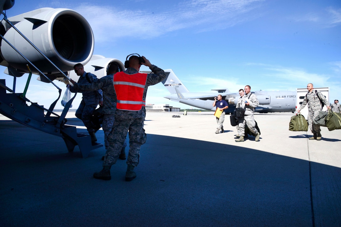 A group of airmen board an aircraft.