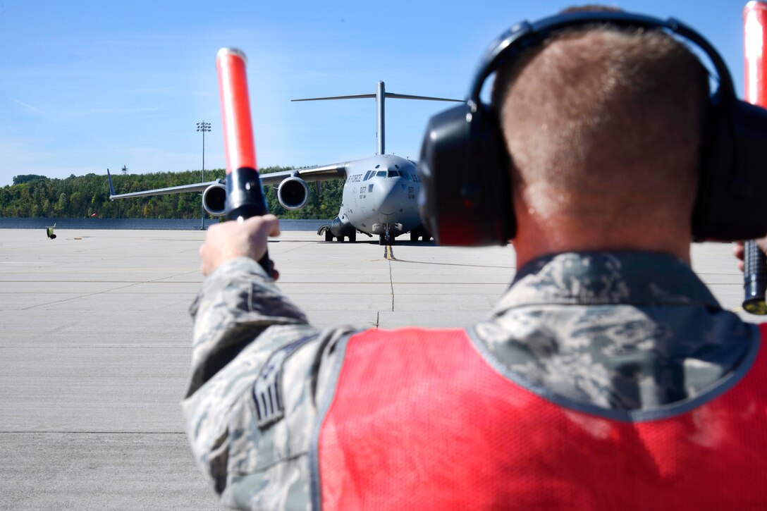 An airman uses hand signals to direct an aircraft.