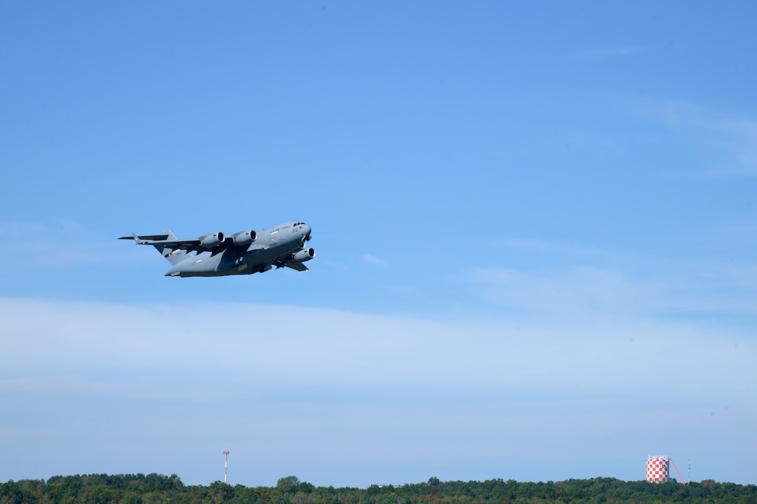 An aircraft is in the air just above the ground.