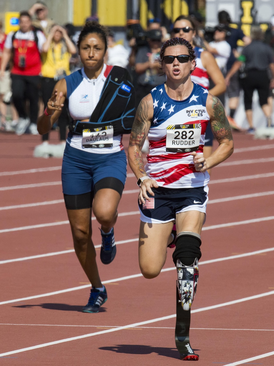 Retired Marine Corps Cpl. Sarah Rudder, right, competes in the women's 100-meter dash.