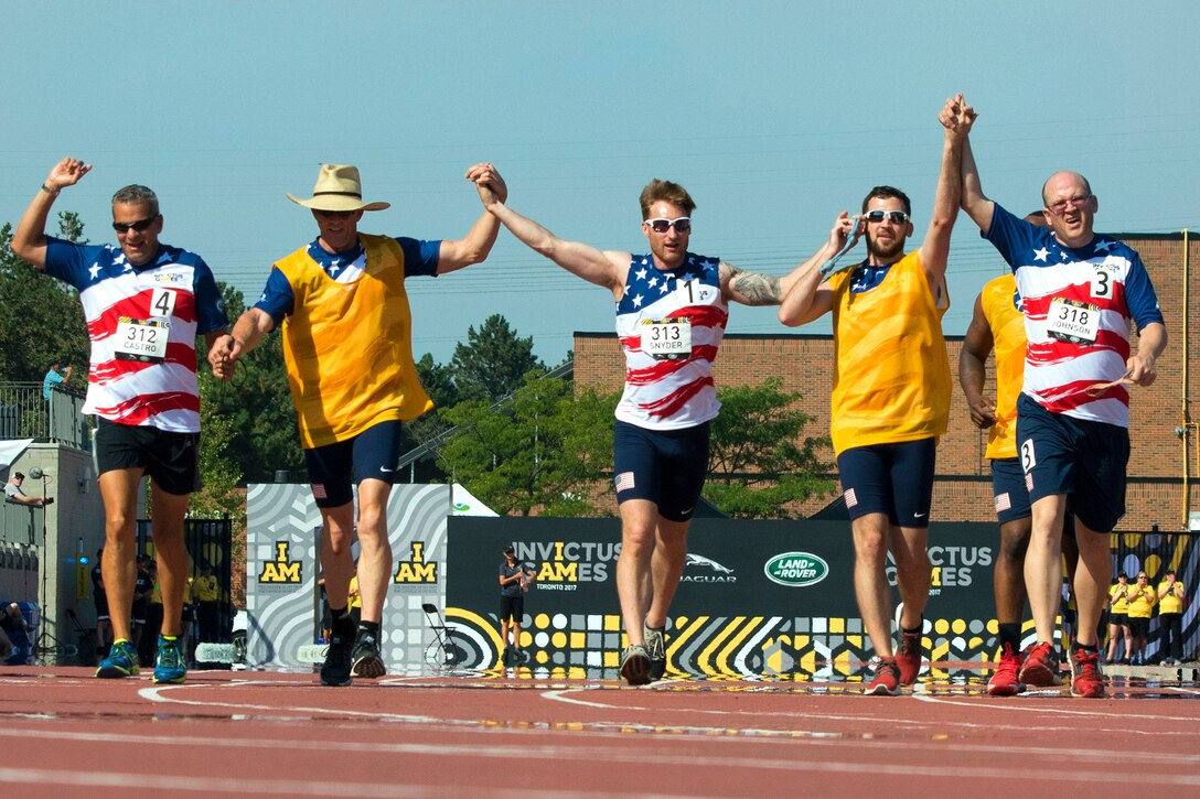 Team U.S. members, visually impaired runners join hands to finish their 1500 meter race as a team.