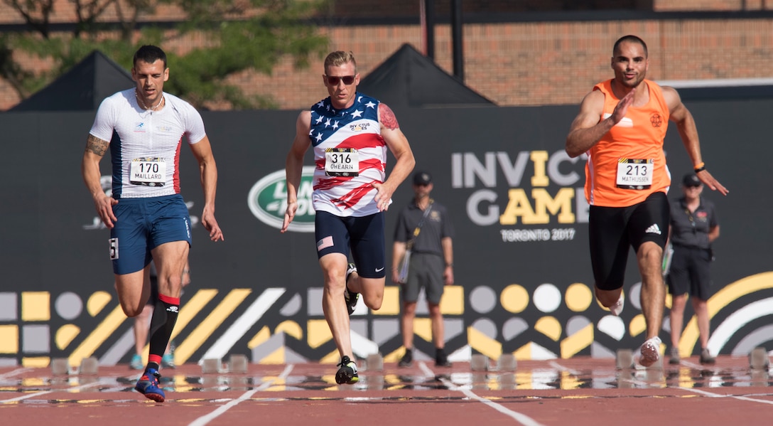 France's Pierre Maillard, left, U.S. Special Operations Command Lt. Col. Dave O’Hearn, center, and Netherlands' Paulus Mathijssen sprint during a 100 meter race.