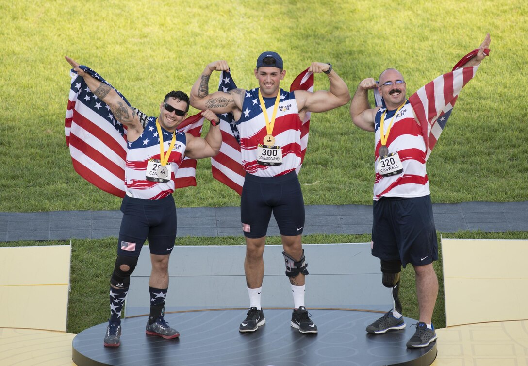 Air Force Staff Sgt. Vince Cavazos, left, Marine Corps Lance Cpl. Michael Sousa Docarmo, center, and Air Force Tech. Sgt. Jason Caswell celebrate after winning the silver, gold and bronze medals.