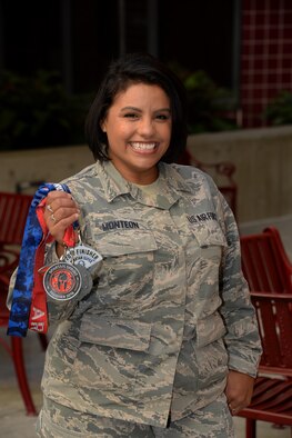 Staff Sgt. Teresa Monteon, 60th Medical Group training manager from San Jose, Calif., poses for a photo with her Reebok Spartan Race medals outside David Grant USAF Medical Center at Travis Air Force Base, Calif., Sept. 22. After a five month battle with cancer, Monteon completed three Spartan races. She plans on running her fourth Spartan race on Sept. 30 in Olympic Valley, Calif. (U.S. Air Force photo by Tech. Sgt. James Hodgman)