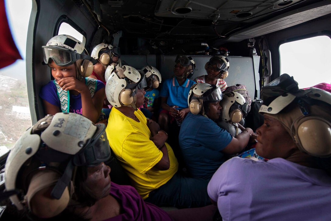 Civilians travel aboard a helicopter.