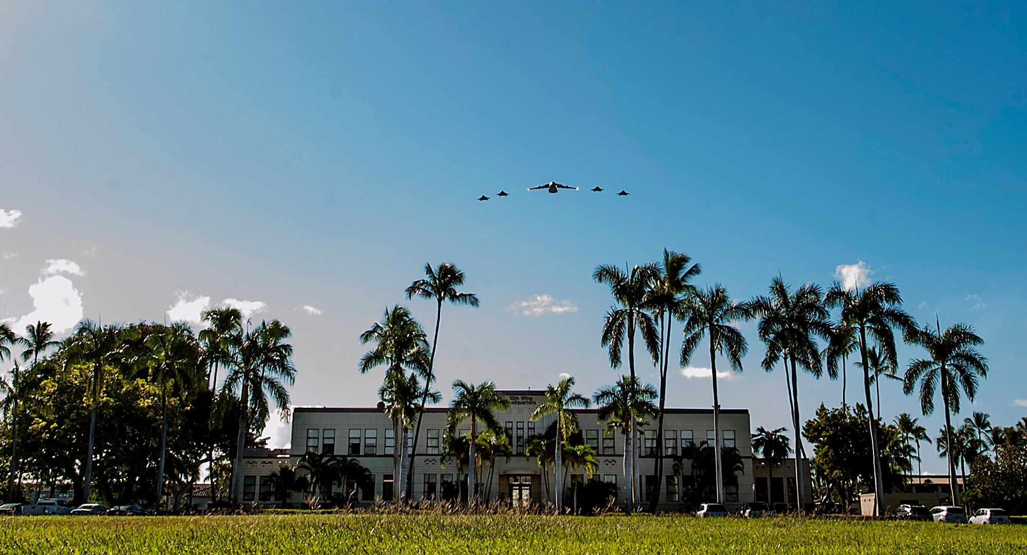 A C-17 Globemaster III and four F-22 Raptors fly in formation over Joint Base Pearl Harbor-Hickam, HI, Sept. 26, 2017.